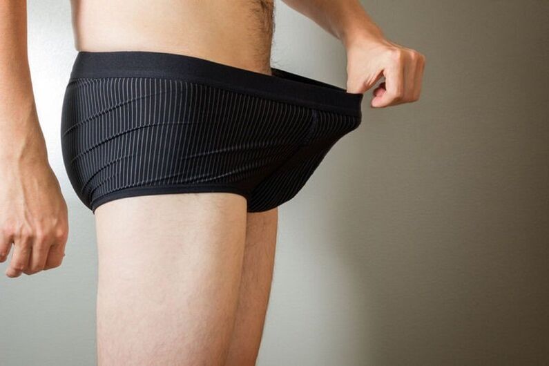 een man kijkt in zijn broek en wil zijn penis vergroten met frisdrank