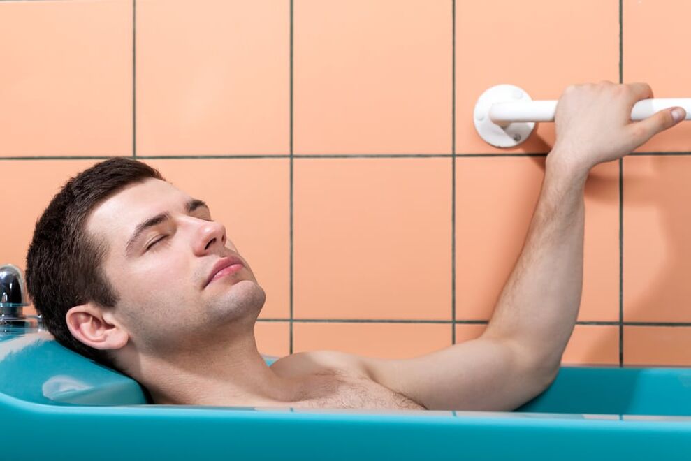 een man neemt een bad met zuiveringszout om zijn penis te vergroten